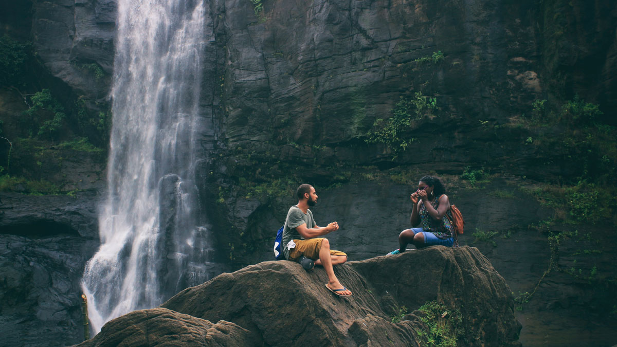 A scenic view of a young man and woman near a waterfallt in Pariyaram in the state of Kerala.